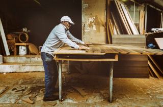 Menuisier au travail sur un établi dans un atelier de caisserie
