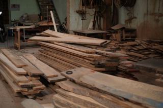 Atelier de menuiserie encombré de planches et de machines