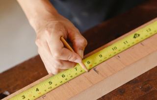 Mesure d'une planche au mètre ruban et au crayon