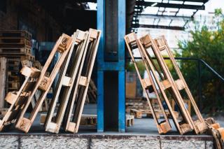 Palettes posées sur chant contre un poteau dans une cour d'usine